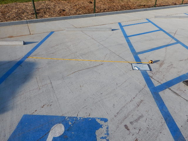 Tape measured being used to measure width of parking spot